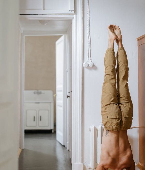 Man performing a controlled strength exercise in a minimalist dark environment.